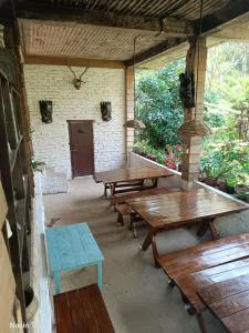 un patio avec des tables et des bancs en bois dans un bâtiment dans l'établissement Tathagata Farm, à Darjeeling