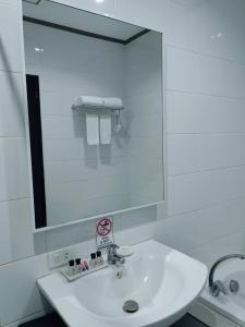 a white bathroom with a sink and a mirror at Batangas Country Club in Batangas City