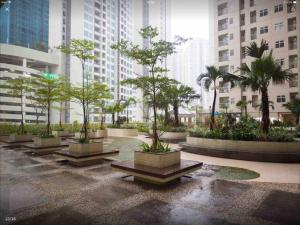 a courtyard with trees and buildings in a city at Madison Park Apartment 2 Bedroom near Central Park Mall in Jakarta