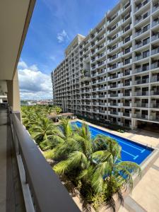 a balcony view of a large apartment building with a swimming pool at Calathea Place by DMCI in Paranaque in Manila