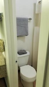 a small bathroom with a white toilet and towels at OSU 2 Queen Beds Hotel Room 131 Wi-Fi Hot Tub Booking in Stillwater