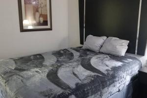a bed in a room with a painting on the wall at OSU 2 Queen Beds Hotel Room 131 Wi-Fi Hot Tub Booking in Stillwater