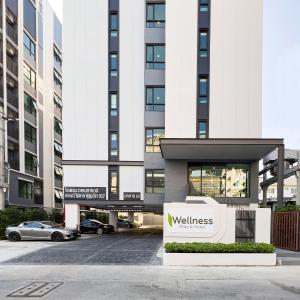 a building with a wellness sign in front of it at Wellness Stay & Hotel Sukhumvit 107 in Bangna