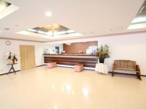 a large room with a waiting room with flowers on a table at 川内ホテル in Satsumasendai