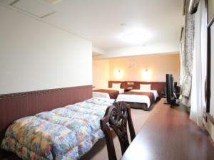 a hotel room with two beds and a television at 川内ホテル in Satsumasendai +25 photos