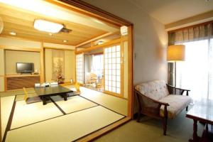 a living room with a table and a chair at 川内ホテル in Satsumasendai