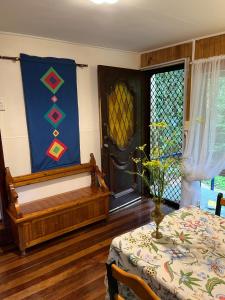 a room with a bed and a table and a window at English Gardens - Forest Spa Suite in Springbrook