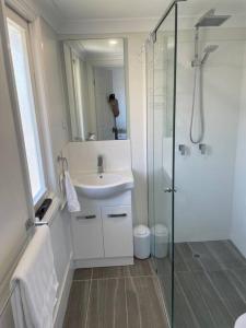 a white bathroom with a sink and a shower at 13 Cypress Lane in Woorim +27 photos