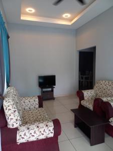 a living room with two couches and a flat screen tv at Yaths homestay in Butterworth
