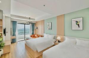 a hotel room with two beds and a view of the ocean at TMS HONG MY QUY NHON BEACH in Quy Nhon