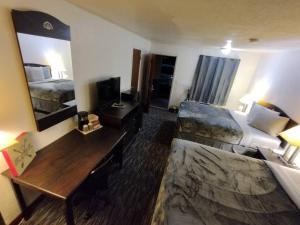 a hotel room with two beds and a desk at OSU 2 Queen Beds Hotel Room 201 Wi-Fi Hot Tub Booking in Stillwater