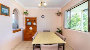 een eetkamer met een houten tafel en stoelen bij Water Views - Top Floor -Clearview Apartments South Esp, Bongaree in Bongaree