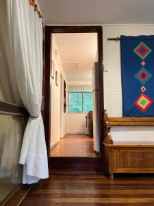 a room with a bed and a hallway with a doorway at English Gardens - Forest Spa Suite in Springbrook