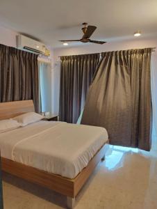 um quarto com uma cama e uma ventoinha de tecto em Tara Suites Premium rooms in Central Indiranagar em Bangalore