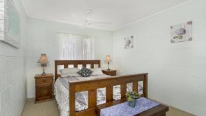 a bedroom with a bed and two lamps and a window at First floor unit close to shops, park and waterfront! in Bongaree