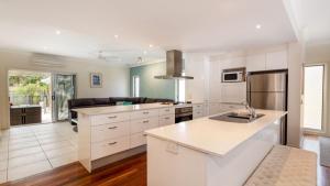 a kitchen with white cabinets and a counter top at Stunning Waterfront Home with pool - Sylvan Beach Esp, Bellara in Bellara