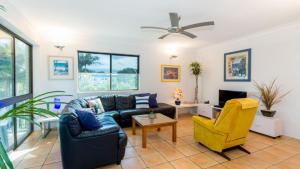 a living room with a couch and a chair at VIEWS VIEWS VIEWS! Front Top Floor Waterfront Unit - Chnook Apartments South Esp, Bongaree in Bongaree