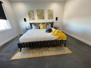 una camera da letto con un letto con una coperta gialla sopra di Stunning 3BR Luxury Home N/Edm*2 king beds* a Edmonton