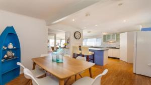 a kitchen and dining room with a wooden table and chairs at Dog Lovers Retreat in Beachmere