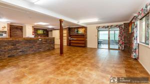 an empty living room with a brick wall at Banksia Gem One Street Back From Waterfront in Banksia Beach