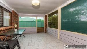 a screened porch with a table and chairs on a house at Banksia Gem One Street Back From Waterfront in Banksia Beach +10 photos
