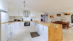 eine Küche mit weißen Schränken und ein Esszimmer in der Unterkunft Bribie Escape, Top Floor Unit with Waterviews in Bellara