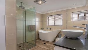 ein Badezimmer mit Badewanne und Glasdusche in der Unterkunft Bribie Escape, Top Floor Unit with Waterviews in Bellara + 14 Fotos