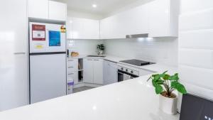 a kitchen with white appliances and a white counter top at Uninterruped Waterviews in Bongaree