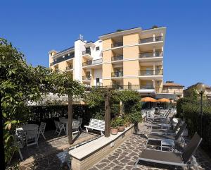 a building with chairs and tables in front of a building at Hotel Imperial in San Benedetto del Tronto