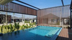 - une grande piscine dans une cour avec un bâtiment dans l'établissement LARGE & QUIET 3bd Home with Security & Pool, à Ubon Ratchathani
