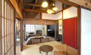a living room with a couch and a table at ロフトが付いた沖縄古民家で寛ぎの時間を 懐かしくて新しい 海野24 in Nanjo