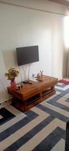 TV sobre una mesa de madera en una habitación en Zuri Stays Machakos Town, en Machakos