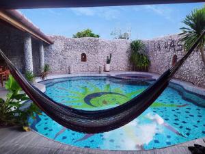 a hammock in front of a house with a pool at Hotel La Hasienda in Kupang