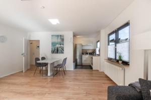 a living room and dining room with a table and chairs at Großer Plöner See, Terrasse, Garten, Grill, Garage in Plön