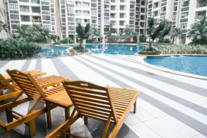 a group of chairs sitting next to a swimming pool at COZY home Country Garden at DangaBay of JB, FREE wifi and streaming in Johor Bahru