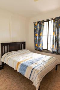 a bedroom with a bed and a window with curtains at Finca Pura Villa in San Lorenzo