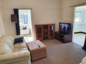 un soggiorno con divano e TV di Parlour Mountain Cottage 