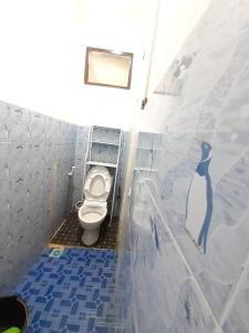 a bathroom with a toilet with a penguin painted on the wall at Homestay Berkah Syariah Bukittinggi in Bukittinggi