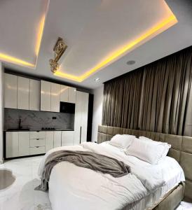 ein Schlafzimmer mit einem großen weißen Bett und einem TV in der Unterkunft Luxury Studio apartments Chevron lekki in Lekki