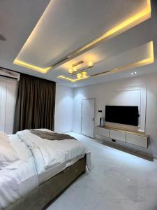 ein Schlafzimmer mit einem großen Bett und einem Flachbild-TV in der Unterkunft Luxury Studio apartments Chevron lekki in Lekki