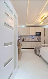 Dieses weiße Zimmer verfügt über ein Bett und eine Küche. in der Unterkunft Luxury Studio apartments Chevron lekki in Lekki