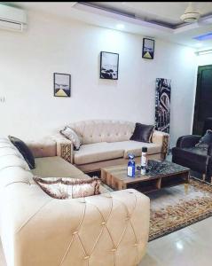 ein Wohnzimmer mit 2 Sofas und einem Couchtisch in der Unterkunft Appartement luxueux ouaga2000(2 chambres ) in Ouagadougou