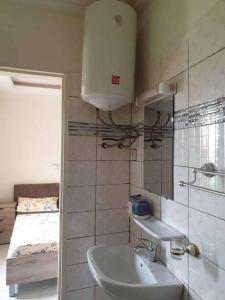 ein Bad mit einem Waschbecken und ein Bett in einem Zimmer in der Unterkunft Appartement luxueux ouaga2000(2 chambres ) in Ouagadougou