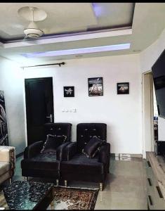 a living room with two leather couches and a ceiling at Appartement luxueux ouaga2000(2 chambres ) in Ouagadougou