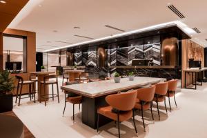 乔治市Citadines Connect Georgetown Penang的餐厅内的酒吧,配有桌椅