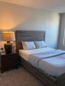 een slaapkamer met een bed met een lamp op een nachtkastje bij New home less than 5 minutes from Lackland Base private room in San Antonio