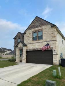 een huis met een garage met een Amerikaanse vlag erop bij New home less than 5 minutes from Lackland Base private room in San Antonio