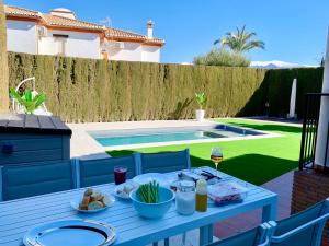 a blue table with food on it in a backyard at VILLA CIUDAD GOLF PLAYA MONTAÑA in Otura