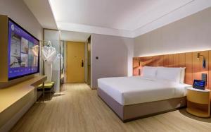 Tempat tidur dalam kamar di Manxin Hotel Guangzhou Baiyun Airport Branch