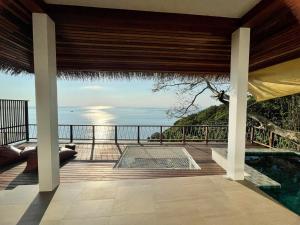 a patio with a pool and a view of the ocean at The AVA Resort Koh Tao in Ko Tao